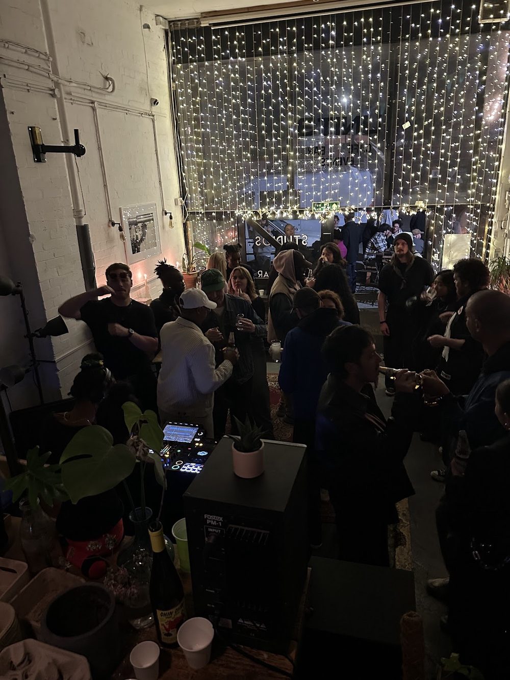A busy evening at UNIT3, a crowd in front of a fairy-light curtain