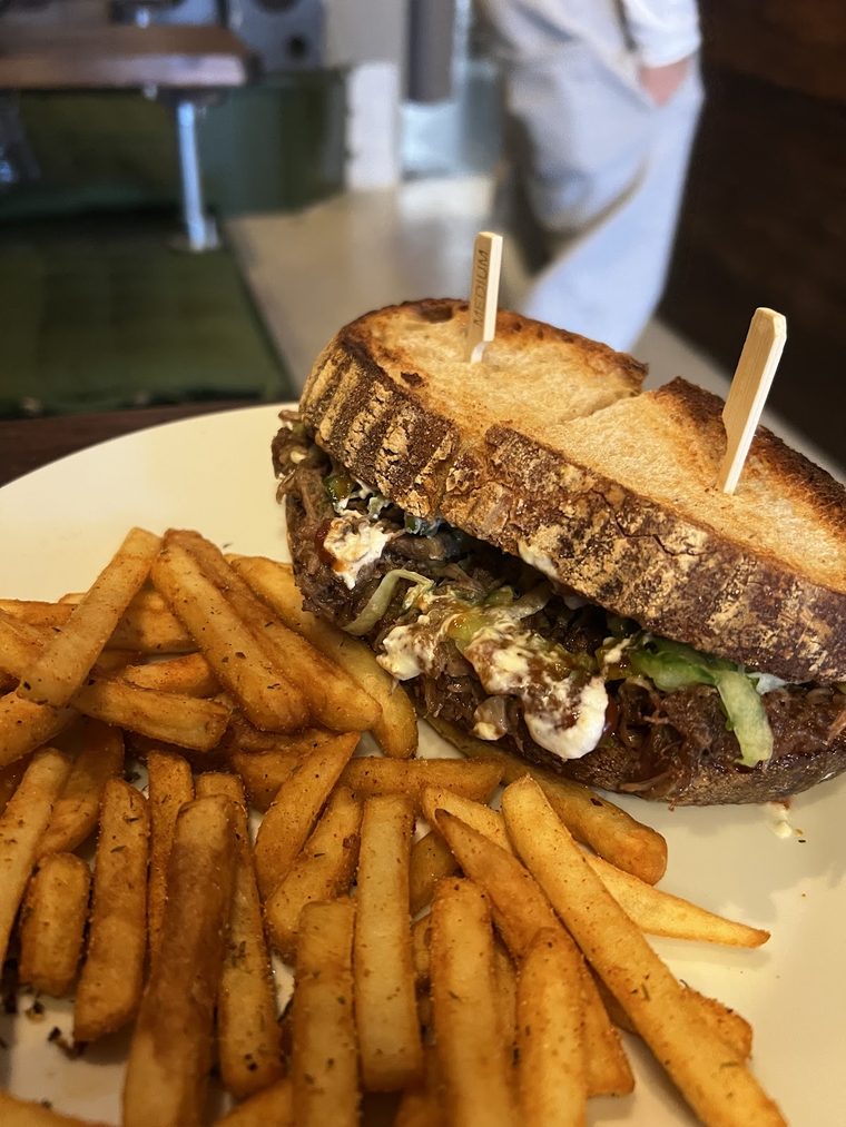 A toasted cheese and chicken sandwich cut in half on a dark plate